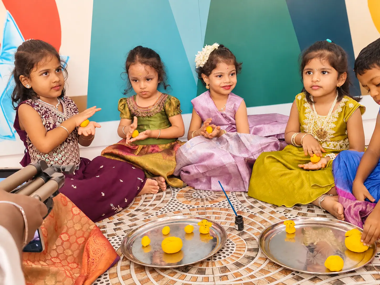 A group of preschool girls seated calmly together during a supervised, hands-on group activity at Little Pumpkien